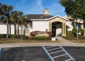 Thumbnail 2 of 15 - Clubhouse with parking lot view surrounded by palm trees