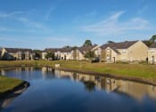 Thumbnail 4 of 15 - Community lake with building exteriors.