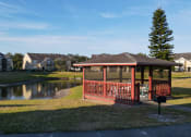 Thumbnail 5 of 15 - Gazebo with BBQ Grill and bench over looking the lake surrounded by trees