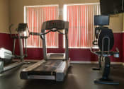 Thumbnail 12 of 15 - Fitness center with treadmill, exercise bike, elliptical, and tv mounted on wall