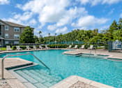 Thumbnail 3 of 24 - Swimming pool with lounge seating surrounded by native landscaping