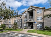 Thumbnail 23 of 24 - Apartment building exterior surrounded by native landscaping