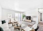 Thumbnail 17 of 25 - Modell Apartment with Couch, Armchairs, Coffee Tables, Entertainment Center and TV Next to Sliding Glass Patio Door