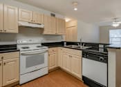 Thumbnail 13 of 24 - Kitchen with Blonde Cabinets, Black Counters and White Appliances