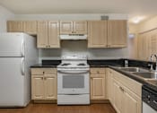 Thumbnail 12 of 24 - Kitchen with Blonde Cabinets, Black Counters and White Appliances