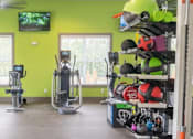 Thumbnail 76 of 197 - A gym with a green wall and exercise equipment at Foxwood Apartments, North Carolina, 27616