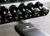Thumbnail 81 of 197 - A black weight rack with green numbers and a black weight plate with a green number 2 at Foxwood Apartments, Raleigh-Durham, 27616
