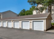 Thumbnail 25 of 31 - Detached Garages Next to Parking Lot with Trees in the Background
