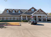 Thumbnail 24 of 24 - Leasing Clubhouse exterior with a parking lot and a black car parked in the front
