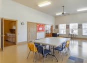 Thumbnail 22 of 27 - Activity room with tables and chairs, ceiling fan, and tile flooring
