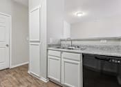 Thumbnail 5 of 27 - A kitchen with a white cabinet and a black dishwasher.