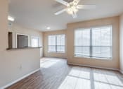 Thumbnail 3 of 33 - a living room with two windows and a ceiling fan. The room opens up to the dining room and kitchen breakfast bar.