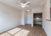 Thumbnail 4 of 33 - a living room with hardwood floors and a ceiling fan. A built-in desk and overhead storage.
