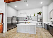 Thumbnail 13 of 33 - a large kitchen with stainless steel appliances and a white island