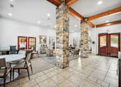 Thumbnail 18 of 33 - the lobby of a lodge with tables and chairs and a stone column