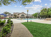 Thumbnail 11 of 33 - A sunny day at the park with a swimming pool and a building in the background.
