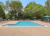 Thumbnail 9 of 29 - A large swimming pool surrounded by trees and lounge chairs.