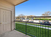 Thumbnail 16 of 27 - A view from a balcony with a white door and a black railing.