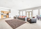 Thumbnail 10 of 25 - Clubhouse Lounge with Armchairs and Kitchen with Wood Cabinets and Stainless Steel Appliances