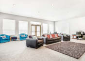 Thumbnail 11 of 25 - Clubhouse Lounge with Armchairs and Kitchen with Wood Cabinets and Stainless Steel Appliances
