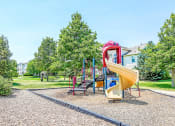 Thumbnail 4 of 25 - Playground on Mulch in Grassy Courtyard with Building Exterior in the Background