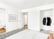Thumbnail 20 of 25 - Model Bedroom with En Suite Bathroom,  Open Closet Next to Bed and Framed Wall Art