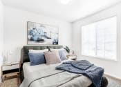 Thumbnail 19 of 25 - Model Bedroom with Bed Under Wall Art, Nightstand Next to Large Window