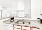 Thumbnail 14 of 25 - Kitchen with Double Basin Sink, Grey Counters and Breakfast Bar