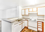 Thumbnail 22 of 25 - Kitchen with White Appliances, Grey Counters and White Cabinets with Wood Accents