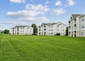 Thumbnail 19 of 29 - A row of apartment buildings with green lawns in front.