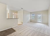Thumbnail 10 of 24 - A spacious room with a carpeted floor and a window with blinds.