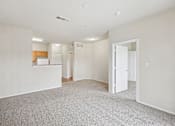 Thumbnail 9 of 24 - A spacious room with a carpeted floor and a door on the right side.