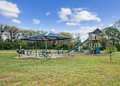 Thumbnail 20 of 24 - A playground with a blue canopy and a yellow slide.