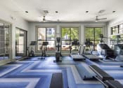 Thumbnail 25 of 39 - a fitness center with treadmills and other exercise equipment