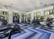 Thumbnail 26 of 39 - a large fitness room with cardio equipment and windows