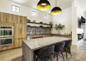 Thumbnail 33 of 39 - a kitchen with wooden cabinets and a large island with a marble countertop
