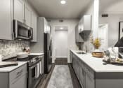 Thumbnail 11 of 39 - a kitchen with gray cabinets and white countertops