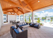 Thumbnail 18 of 58 - a covered patio with couches and tables and a pool