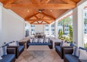 Thumbnail 27 of 58 - a covered patio with blue chairs and a wooden ceiling