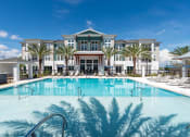 Thumbnail 25 of 58 - a large swimming pool in front of a building with palm trees
