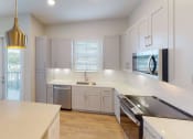 Thumbnail 38 of 58 - a kitchen with white cabinets and stainless steel appliances