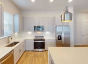 Thumbnail 39 of 58 - a kitchen with white cabinets and a stainless steel refrigerator