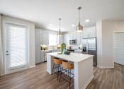 Thumbnail 48 of 58 - a kitchen with white cabinets and a white island with three stools