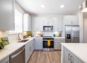 Thumbnail 53 of 58 - a renovated kitchen with white cabinets and stainless steel appliances