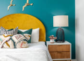 Thumbnail 31 of 58 - a bedroom with a bed and a blue wall with birds on it