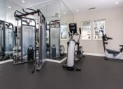 Thumbnail 11 of 44 - a gym with cardio equipment and weights on the floor