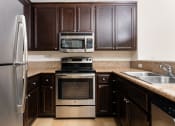 Thumbnail 13 of 44 - a kitchen with stainless steel appliances and brown cabinets