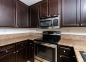 Thumbnail 14 of 44 - a kitchen with a stove microwave and cabinets