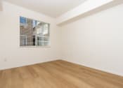 Thumbnail 18 of 44 - a bedroom with white walls and wood flooring and a window