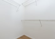 Thumbnail 23 of 44 - a room with white walls and a white closet and a wire rack on the wall